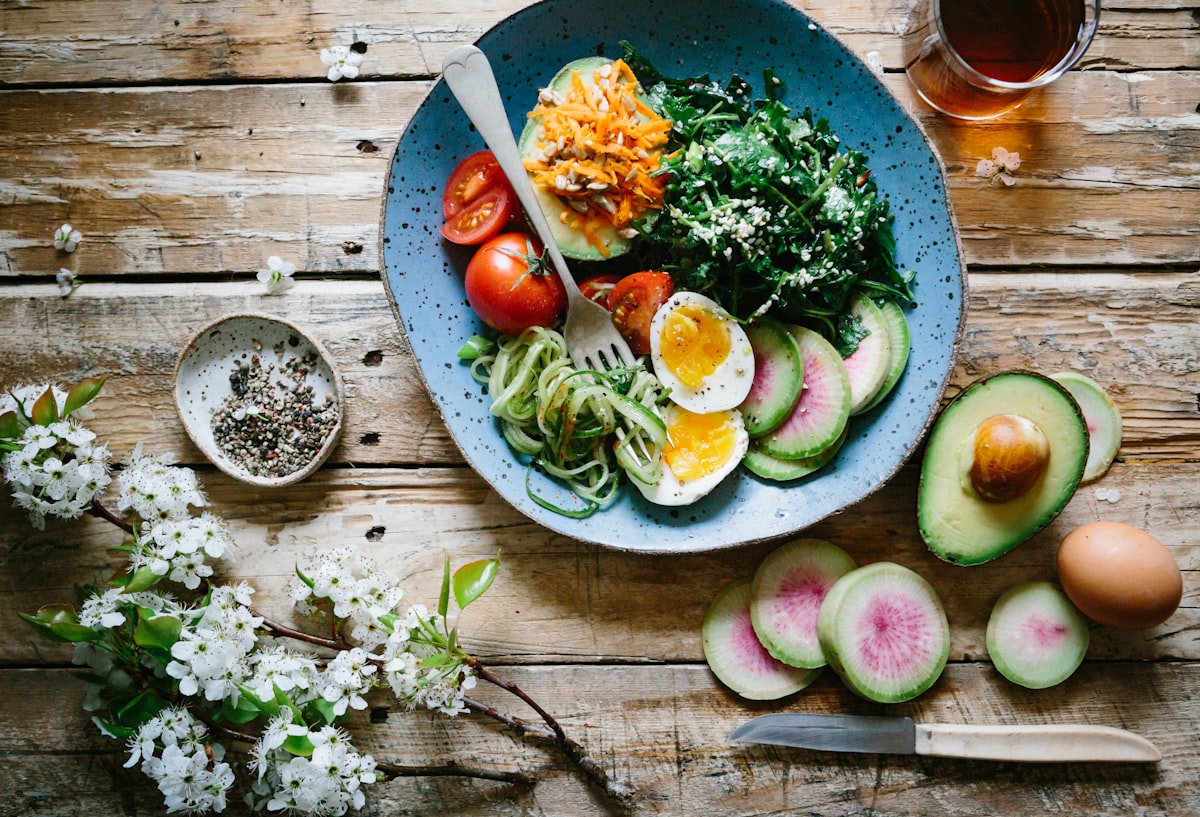 A fresh, balanced bowl of salad, avocado, egg and vegetables